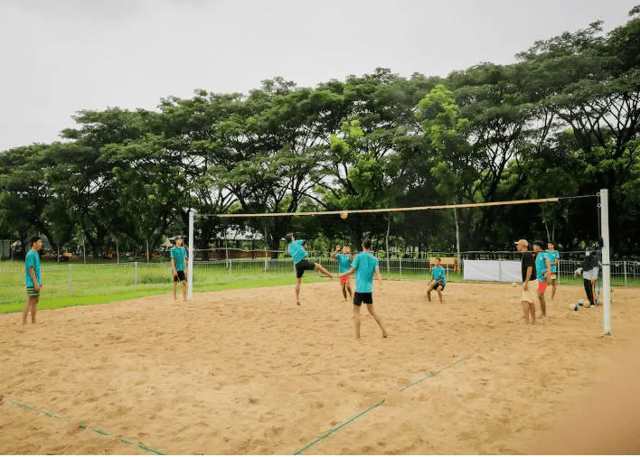 guys playing volleyball barefoot in sand